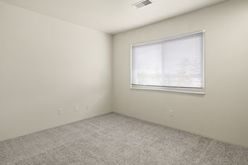 A room with a window and carpeted floor.